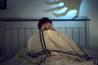 Frightened woman in bed