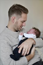 Young father keeps crying infant