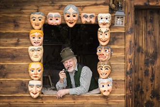 Wooden mask carver in a window