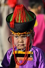 Little girl in traditional Deel clothes and hat with cone-shaped lace