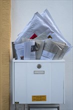 Overfilled mailbox with letters and newspapers