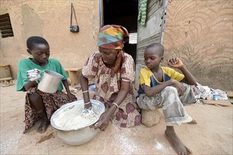 Woman and children kneading dough for flatbread