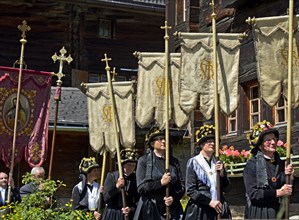 Woman in traditional costumes with church banners