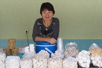 Kazakh woman behind her stall of goat cheese and kumis