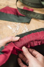 Hands folding and fastening silk ribbon using pins