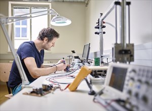 Man soldering in electronics laboratory