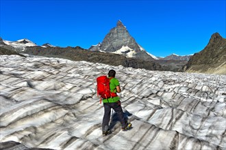 Hiker looks over the furrowed surface of the Gorner Glacier onto the Matterhorn