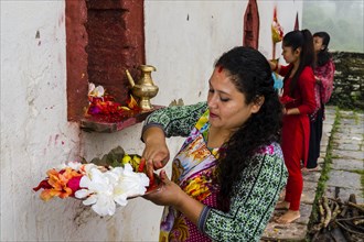 Woman is offering prasad to the statues of gods at hinduist festival Darsain