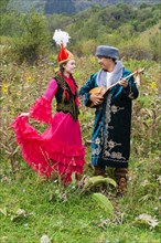 Kazakh man singing and playing the dombra for a woman
