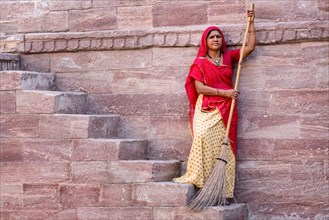 Woman in Sari sweeping steps
