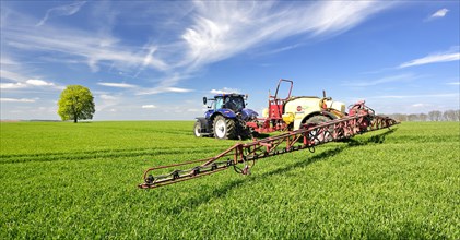 Tractor with sprayer spraying pesticides
