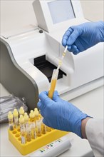 Pharmaceutical technician putting test strips in analyzer