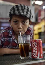 Boy drinking a Coke with a straw