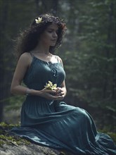 Artistic romantic portrait of a beautiful young woman in a green summer dress