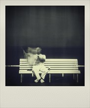 Man reading newspaper on bench
