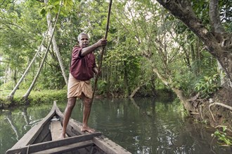 Boatman with punting pole on river