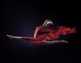 Beautiful woman in mid-air with flowing red cloth wrapping her nude body