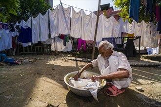 Man doing laundry by hand in courtyard