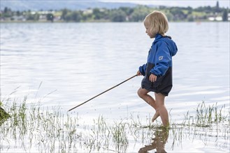 Toddler with Stock trudging in water