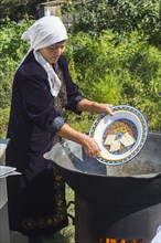 Kazakh Woman preparing the traditional local tandyr bread