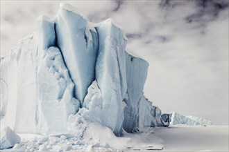 Iceberg seen from frozen fjord