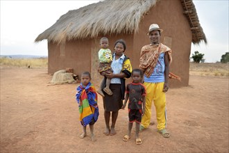 Family with three children in front of hut