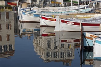 Boats in the harbour with reflections of buildings