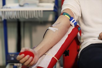 Patient with an infusion needle taking a blood sample at the transfusion ward of a hospital