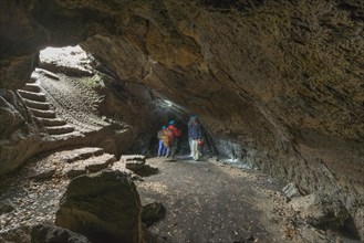 Tourists in the Grotta dei Ladroni lava cave