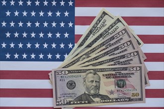 Various US dollar bills on American flag