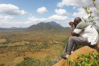 Man with binoculars looking at the Ngulia Hills and the Rhino Valley