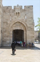 Man with traditional Jewish clothes in front of the city wall