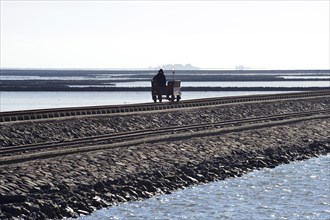 Wagon rolling over dam in Wadden Sea