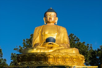 Big golden statue of Shakyamuni Buddha at back of Swayambhunath temple