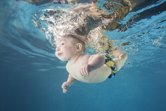 Baby boy diving in the pool