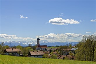 Village with the Parish Church of the Assumption in front of Alps