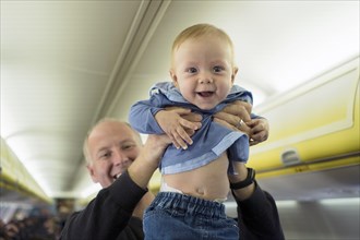 Father standing with his six months old baby boy in the airplane