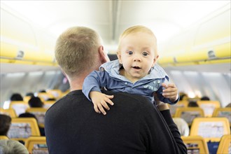 Father with his six months old baby boy in the airplane