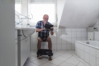 Senior man sitting on the toilet