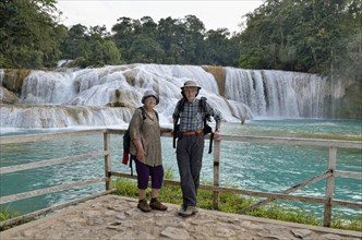 Tourists are standing at the Agua Azul blue water waterfalls
