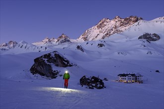 Ski tourer with headlamp in front of Heidelberger Hutte