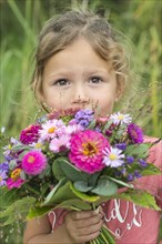 Little girl holding autumn bouquet with Zinnia (Zinnia elegance)