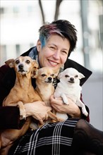Woman with her three dogs on her lap
