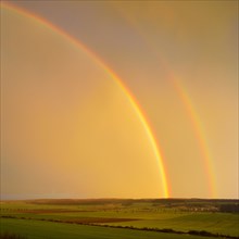 Double rainbow over agricultural landscape