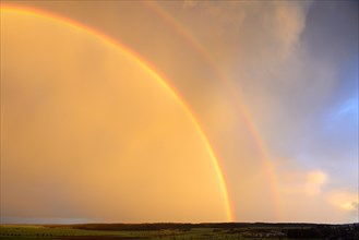 Double rainbow over agricultural landscape