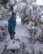 Woman with a snow shovel clearing snow