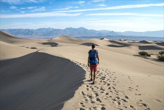 Young man hiking on sand dunes