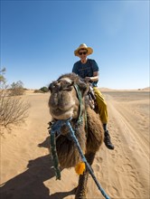 Young man riding on a camel