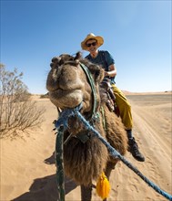 Young man riding on a camel