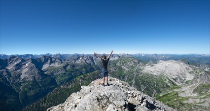 Hiker stretches arms into the air